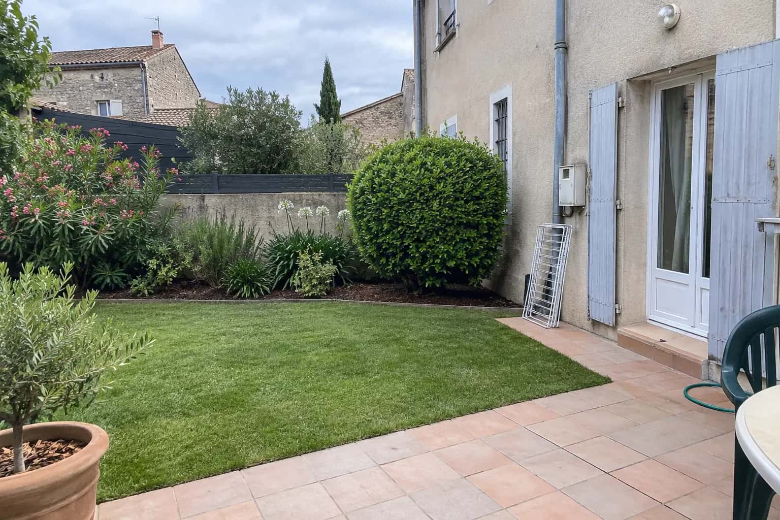 Petit jardin de ville entretenu, pelouse tondue et arbuste taillé